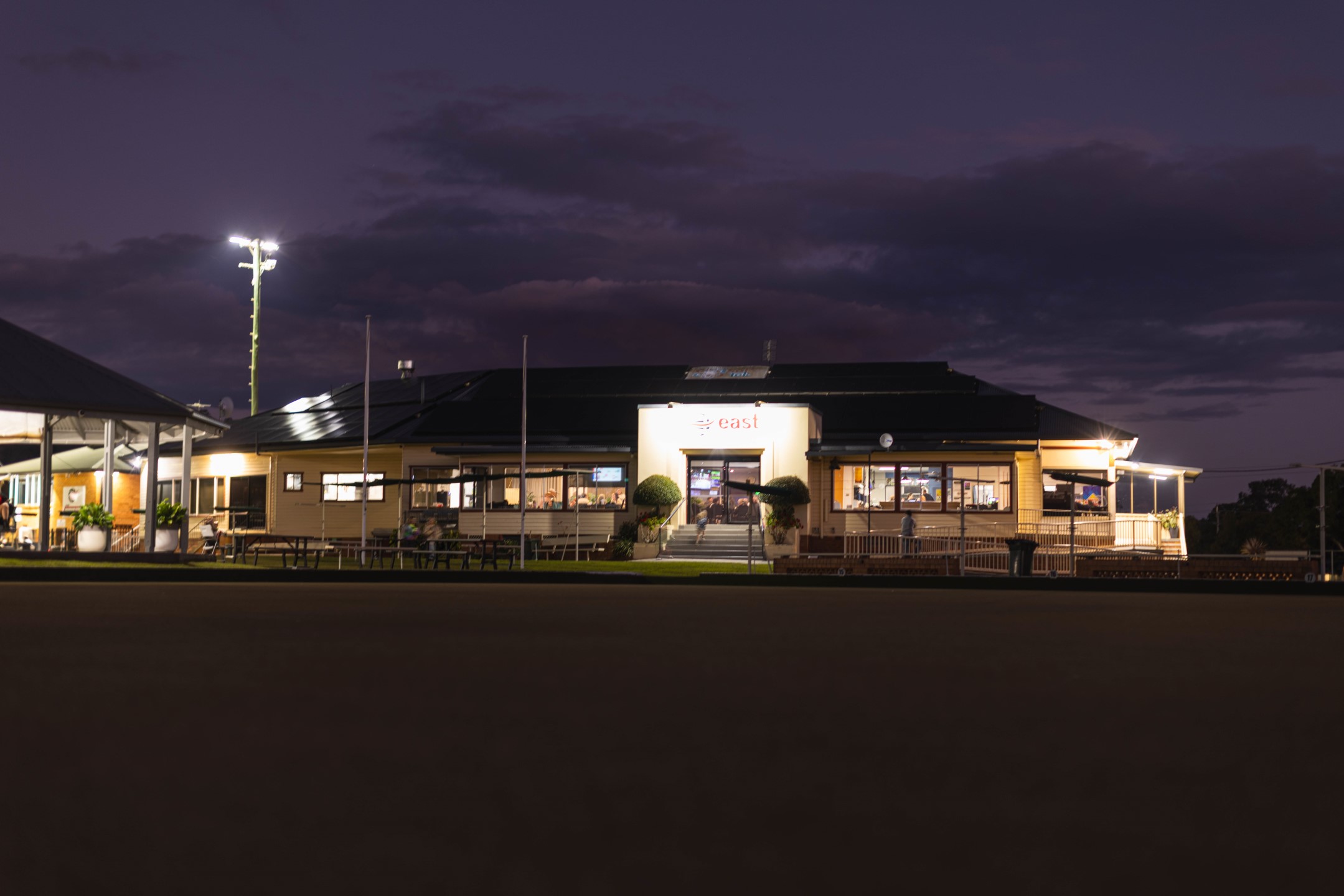 The East Lismore clubhouse lit up at twilight, overlooking the green
